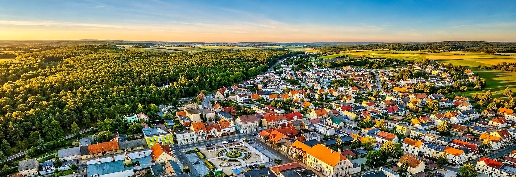 Baner wizerunkowy top Witamy w portalu Gminy Piaski, zdjęcie placu z pomnikiem na środku, rynek miasta